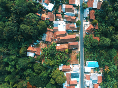 Vue aérienne d'un village entouré d’une forêt verdoyante 